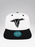 A white and black snapback cap featuring a black embroidered stylized bird logo on the front. The brim is black, and a circular green and white 'Legacy Heritage' sticker is visible on the front.